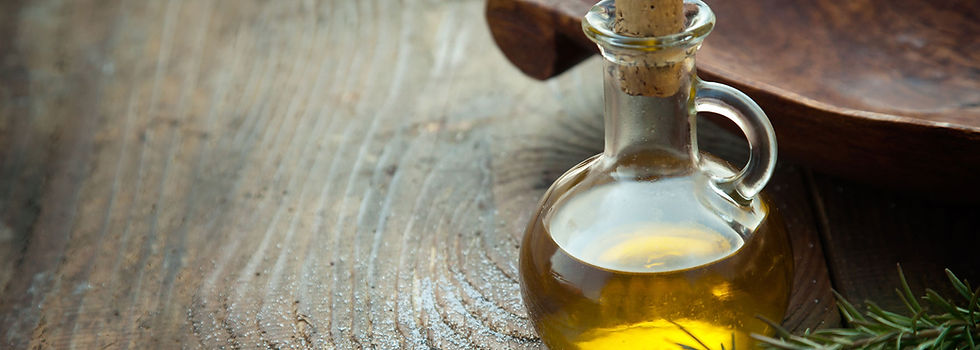 A glass crue with oil in it on a wooden table