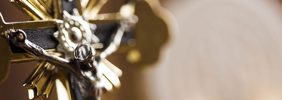 A gold crucifix from the side against a blurred out background